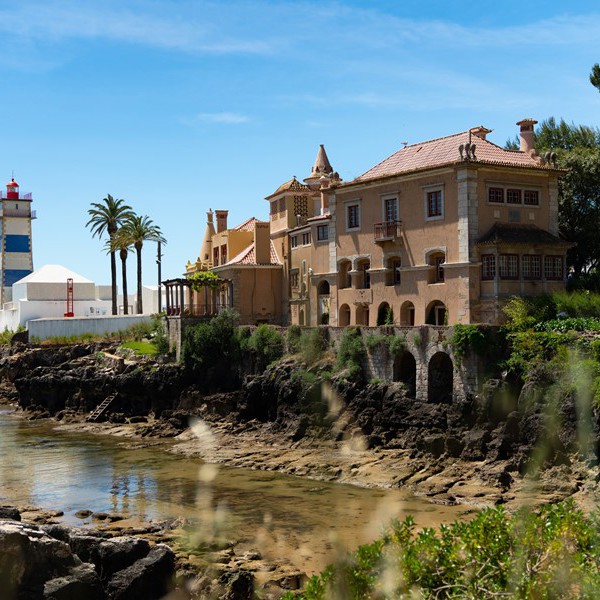 Fyrtårn og smuk bygning ved havet ved Cascais