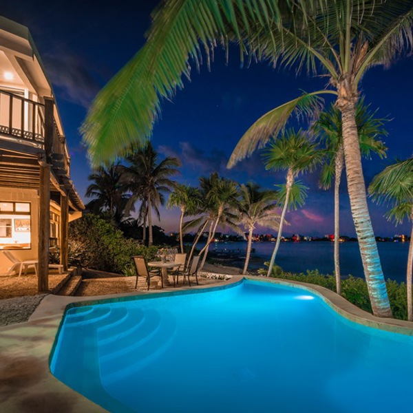 Villa, pool, palmer og havudsigt om aftenen ved Akumal