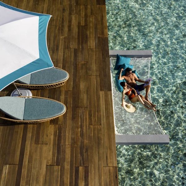 Dagene flyder væk når slapper af i en hængekøje over vandet på Pullman Muumutaa Maldiverne